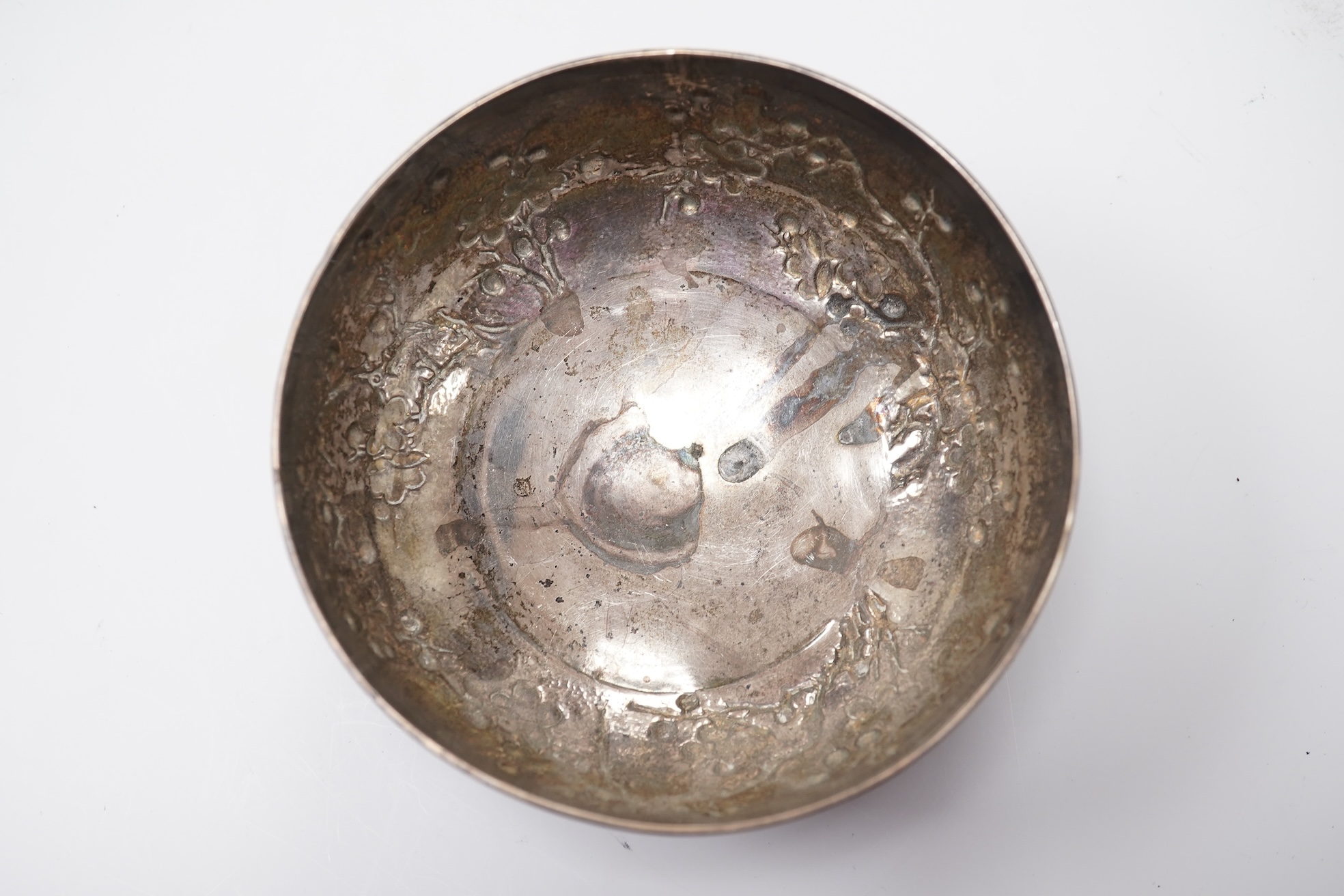 A late 19th/early 20th century Chinese Export white metal bowl, by Wang Hing, Hong Kong, embossed with blossoming prunus branches, diameter 10.6cm, 113 grams.
